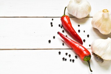 Red chili peppers, garlic on a wooden white background. Copy space, flat lay.