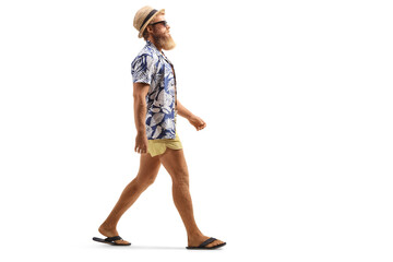 Full length profile shot of a bearded male tourist with sunglasses walking