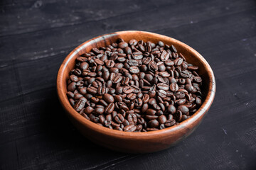 Roasted coffee beans in wooden bowl. Top view. Copy space. Morning concept