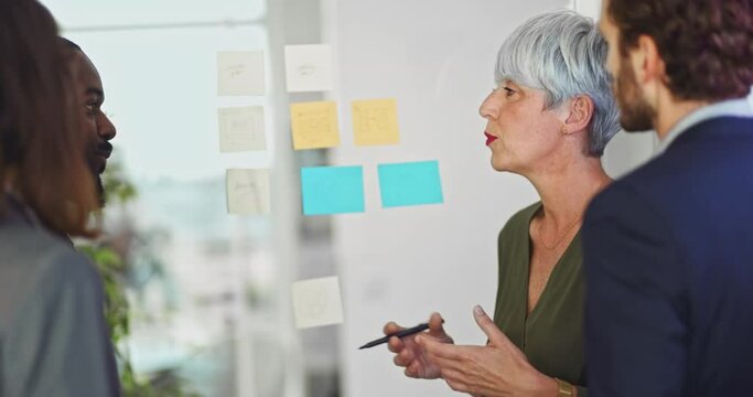 Senior woman with colleagues meeting with sticky notes in office