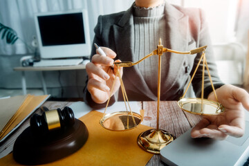 Justice and law concept.Male judge in a courtroom with the gavel, working with, computer and docking keyboard, eyeglasses, on table in morning light