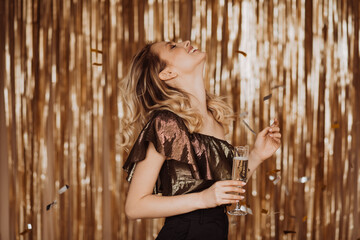 Woman in shiny top laughs wholeheartedly. Lady enjoying party with glass of champagne