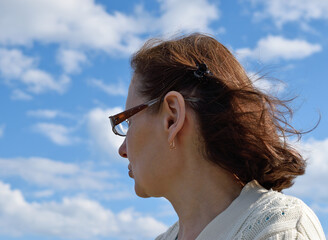 Portrait of a woman on a background of clouds.