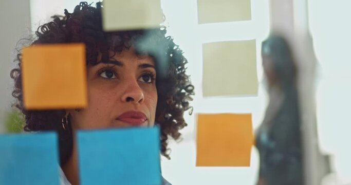 Close-up business woman analysing and reading sticky notes in office