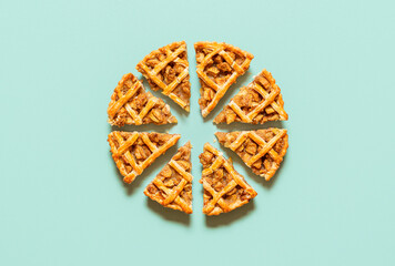 Sliced apple pie with lattice crust isolated on green table. Homemade apple pie, top view