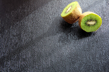 Kiwi on a black textured background. Juicy fruit.