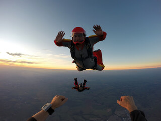 Point of view of a parachutist at sunset, almost at night, when jumping with friends.
