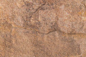 Textured brown stone rock surface close up