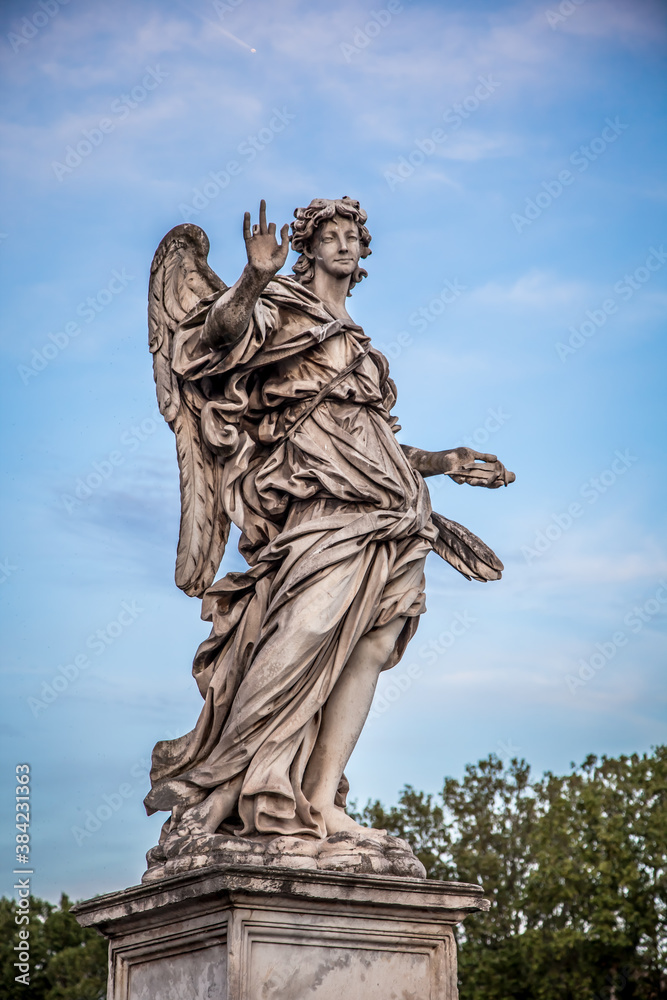 Wall mural Statue of an angel against the blue sky on the bridge of Sant'angelo in Rome, Italy