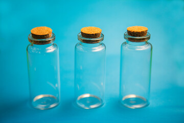 small three empty glass containers on blue background