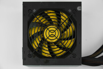 Dusty, dirty power supply. Black case, yellow propeller power supply. Uncleaned, dusty power supply.