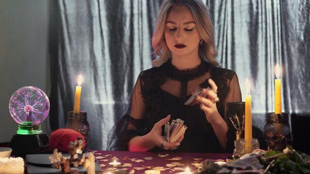 Gypsy fortune teller shuffling occult tarot cards. Magical pagan destiny reading ritual.