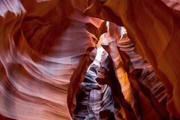 A view of the path through upper antelope canyon in northern arizona. This famous slot canyon is filled with light pockets and banded canyon walls.