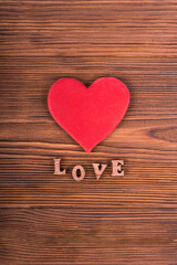 Red heart with the text love on a wooden background. Postcard or wallpaper with congratulations on valentine's day, recognition of feelings, valentine.