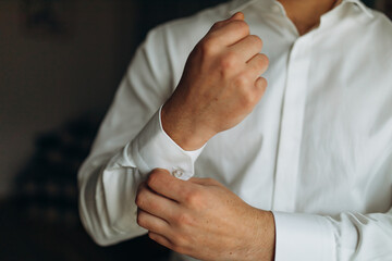 man buttons shirt, a man in a white shirt, morning groom, hands of a man close-up, a white shirt on a businessman, man buttons shirt sleeve, businessman puts on a suit