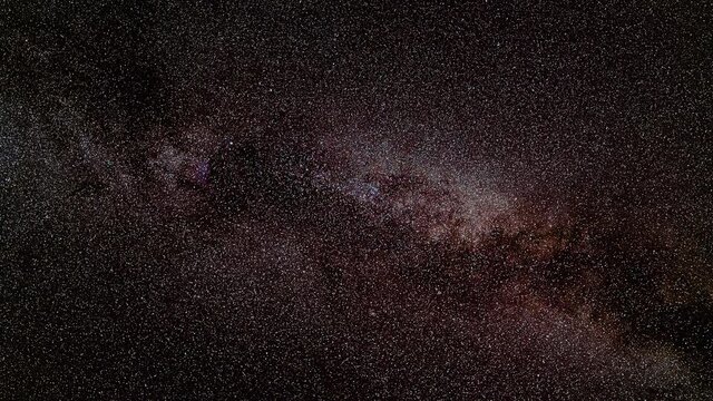 Night sky timelapse, many stars with satellites passing by, Milky way in region of Cygnus constellation visible