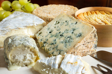 French cheese - camembert, roquefort, brie, goat cheese and epoisse with grapes close-up