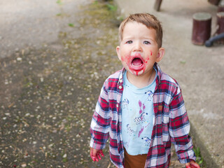 Upset boy with dirty face opened his mouth.