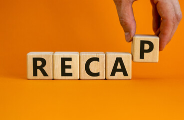 Wooden cubes with word 'recap'. Male hand. Beautiful orange background. Business concept. Copy space.