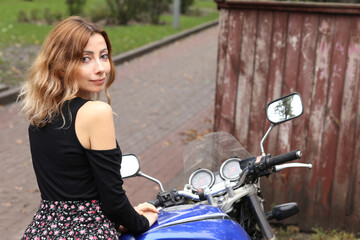 Obraz na płótnie Canvas Pretty woman sitting on the motorcycle