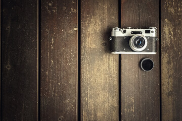 Retro camera made of metal on a wooden background made of boards