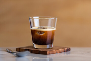 Ice coffee in a glass on a marble counter. Copy space.