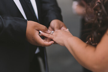 a latin-american bride and an afro-american groom exchange rings at a wedding