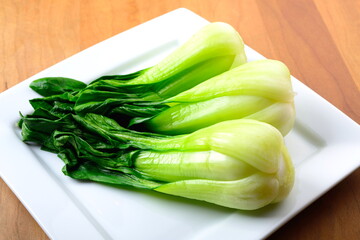 Steamed bok choy on a white plate