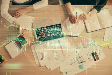 Double exposure of woman hands working on computer and forex graph hologram drawing. Top View. Financial analysis concept.