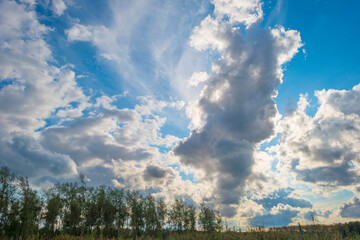 Dark, gray and white rain clouds and a blue sky over a windy rainy city in bright sunlight in autumn, Almere, Flevoland, The Netherlands, October 9, 2020