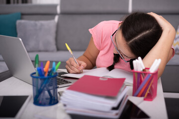 Social distancing student concept, education at home. High school girl doing homework at home with laptop. Teen study home the school is closed during Coronavirus Covid-19.