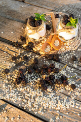 Morning yogurt with the addition of ripe blackberries. On a wooden table.