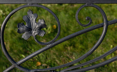 A fragment of cast-iron fence with a maple leaf