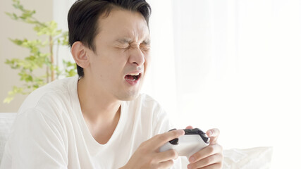 リビングでテレビゲームをする男性