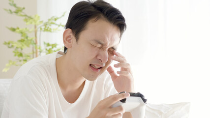 リビングでテレビゲームをする男性