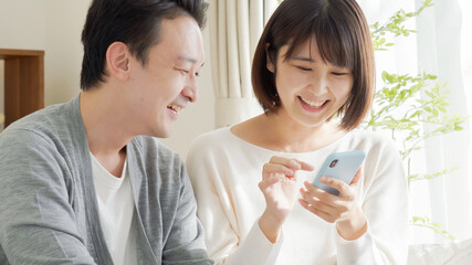 スマホを操作する夫婦・カップル