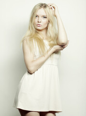 blond woman in white dress posing in studio
