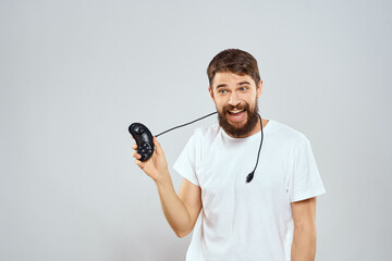 A man with a joystick in his hands fun games lifestyle white t-shirt light background