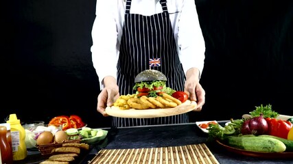 Hands of chef wear black apron holding plate with set fresh vegetable hamburger giving for customer while standing on the workshop. Homemade food concept.