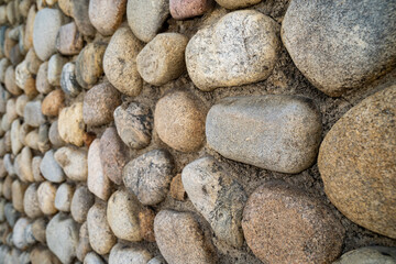 Large stone rock wall, closeup, in selective focus. Useful for backgrounds