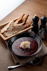 Cold russian beetroot soup with scallop in a russian fancy restaurant, top view on wooden table