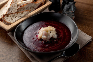 Cold russian beetroot soup with scallop in a russian fancy restaurant, top view on wooden table
