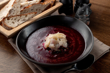 Cold russian beetroot soup with scallop in a russian fancy restaurant, top view on wooden table
