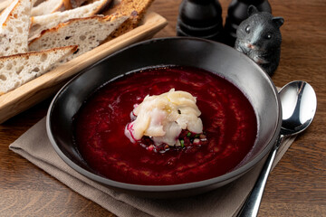 Fine dining russian restaurant: cold borscht in a black designer bowl, modern russian cuisine