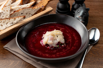 Fine dining russian restaurant: cold borscht in a black designer bowl, modern russian cuisine