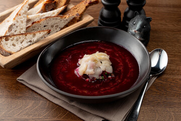 Fine dining russian restaurant: cold borscht in a black designer bowl, modern russian cuisine