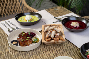 Set table on a summer terrace of modern cuisine restaurant, raffia furniture, photo on daylight