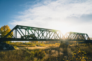 Maintenance Trains Crossing Truss Bridge in Autumn
