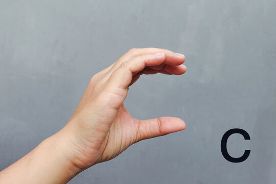 Hand Showing Sign of C Alphabet, isolated on grey background. Sign language  