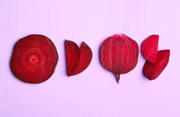 Flat lay composition with cut raw beets on pink background